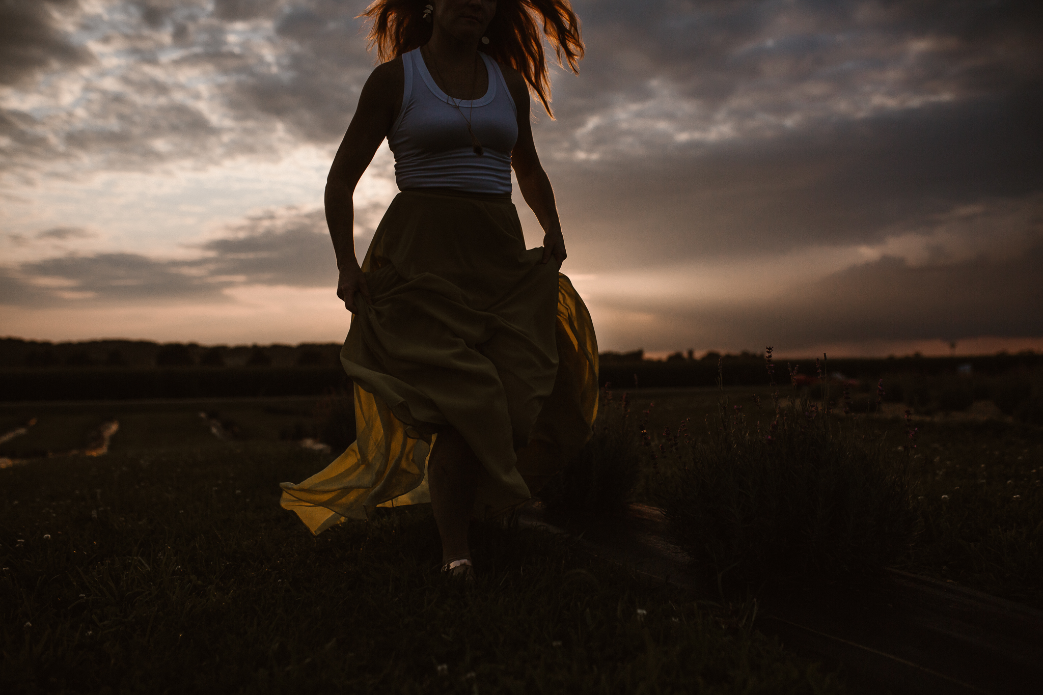 Red headed woman in yellow skirt at sunset in a lavender field.